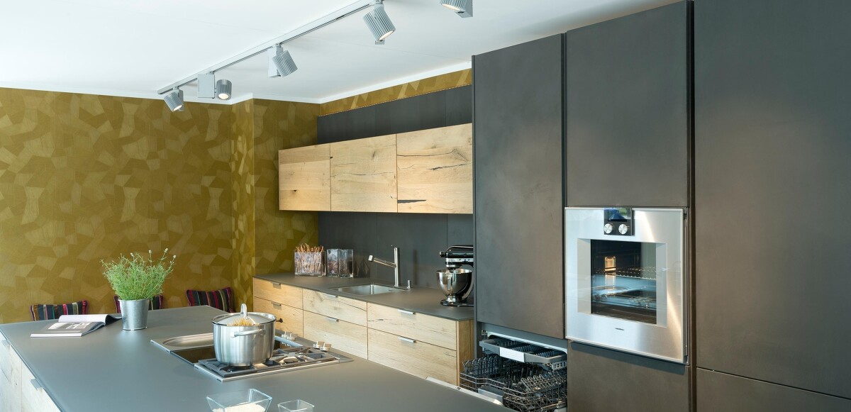 Küche mit handgespachtelten Betonfronten und österreichischem Altholz kombiniert