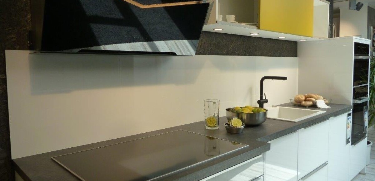 Kristallweiße hochglänzende Echtglasfront kombiniert mit Curryfarbiger Oberschrank Schiebetüre, Nischenverkleidung Glas, Schichtstoff-Arbeitsplatte