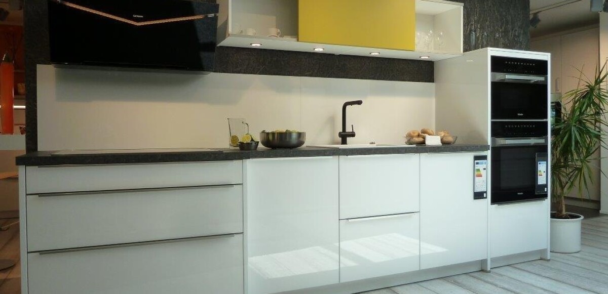 Kristallweiße hochglänzende Echtglasfront kombiniert mit Curryfarbiger Oberschrank Schiebetüre, Nischenverkleidung Glas, Schichtstoff-Arbeitsplatte