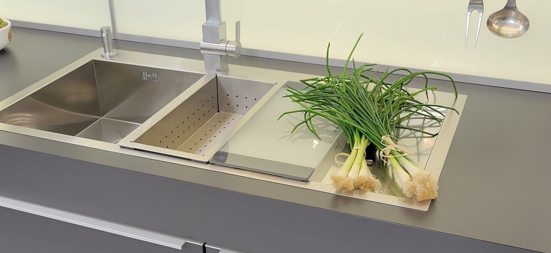 Küchenspüle aus hochwertigem Edelstahl, ergänzt durch genau passendes Schneidebrett und Abtropfbehälter