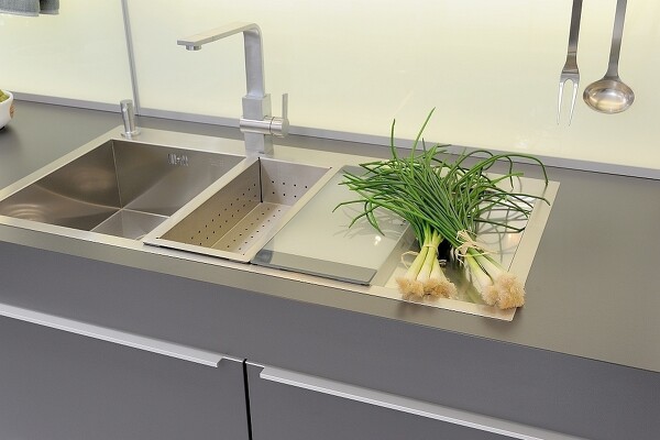 Küchenspüle aus hochwertigem Edelstahl, ergänzt durch genau passendes Schneidebrett und Abtropfbehälter